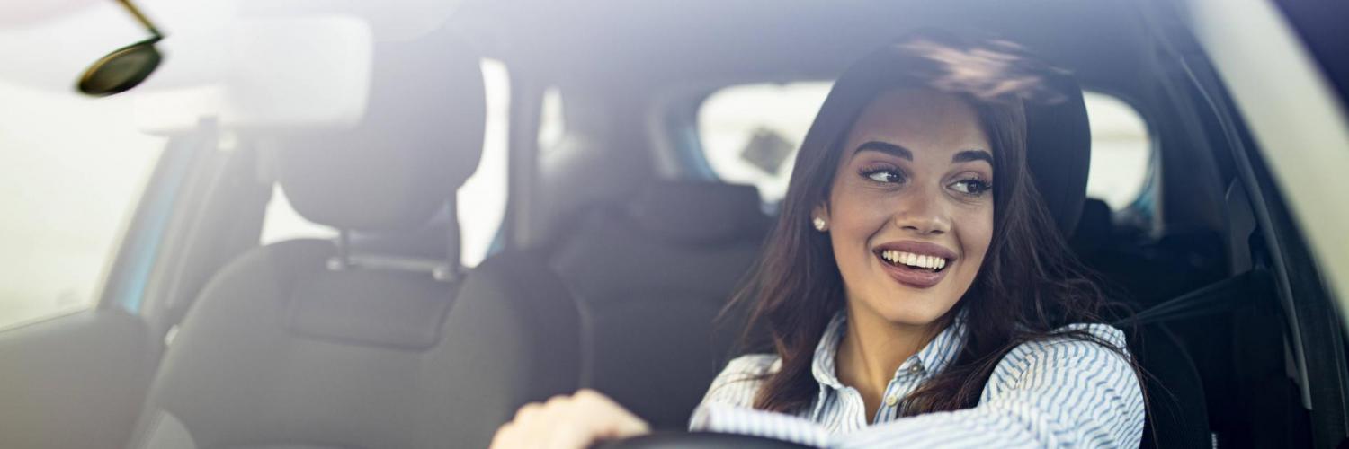 Woman smiling behind the steering wheel