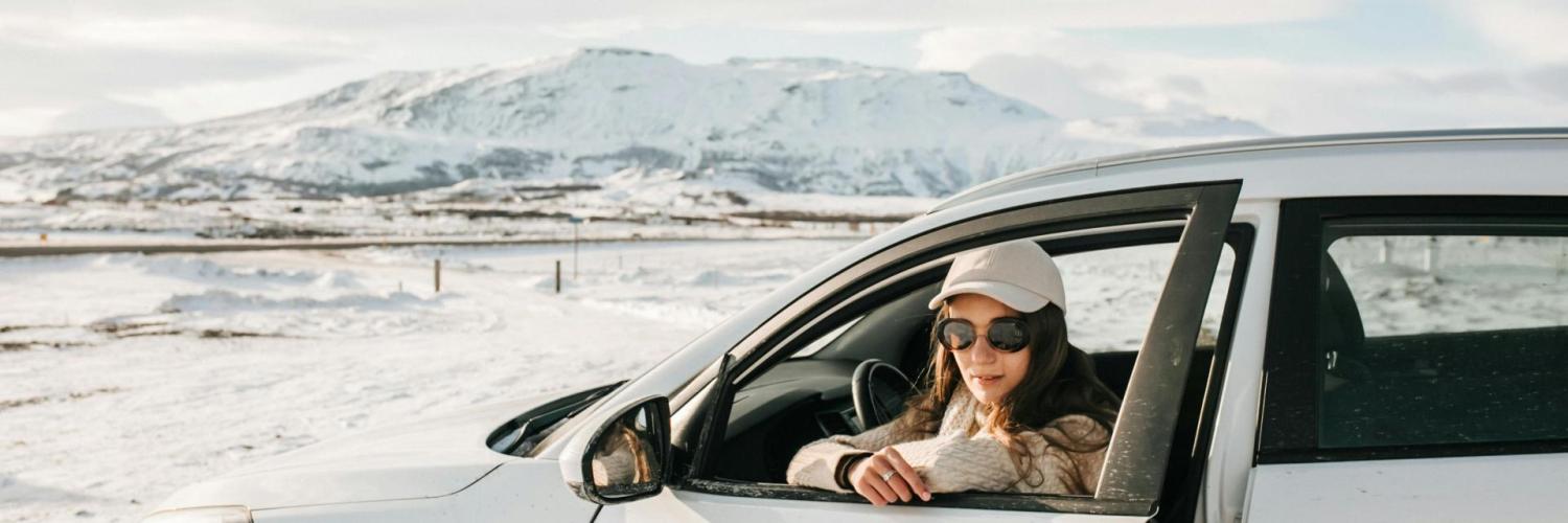 Winter Holidays 2024 A woman sitting in a white car in a snowy landscape
